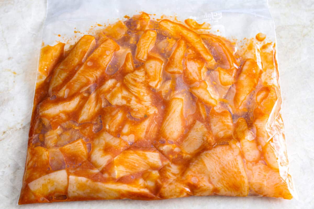 Overhead shot of chicken in a ziplock bag with marinade. 