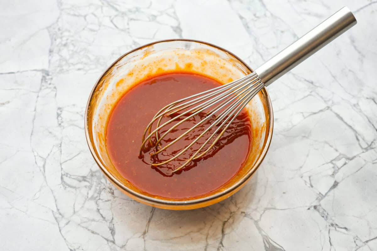 Overhead shot of dragon chicken sauce ingredients whisked together in a bowl. 