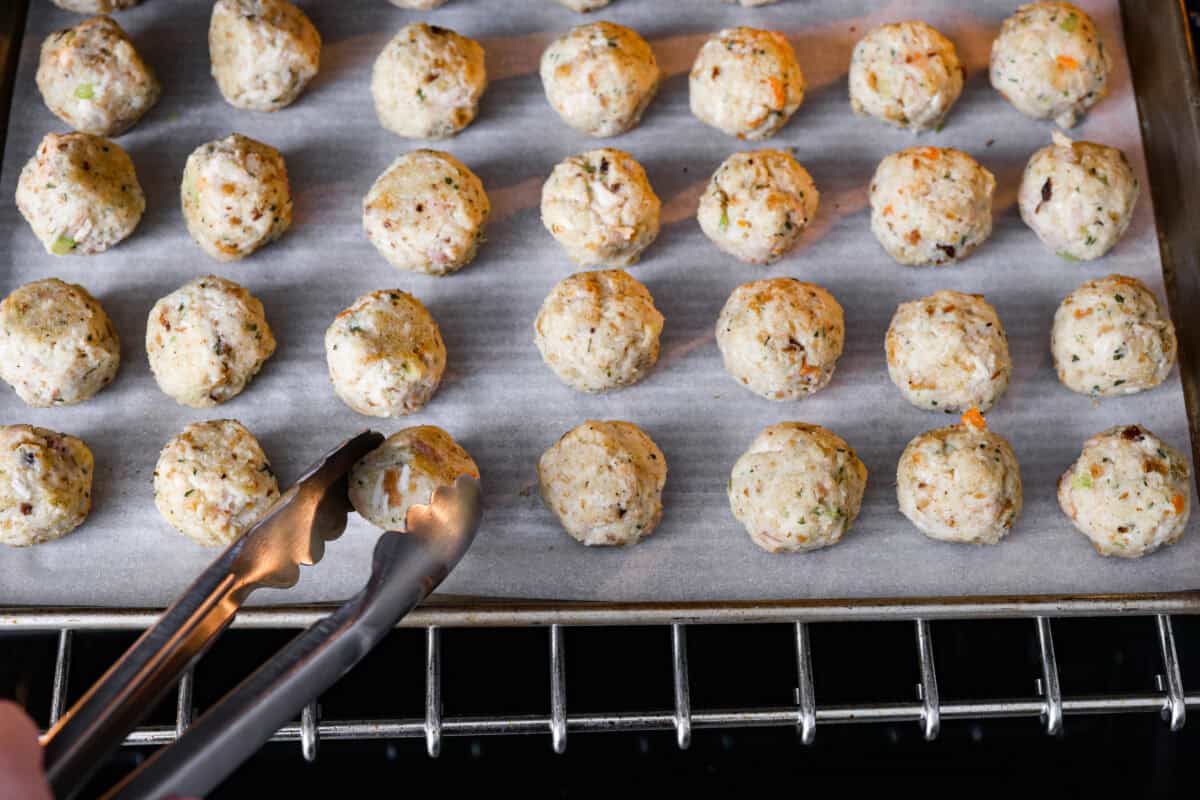 Angle shot of someone flipping the balls in the oven. 