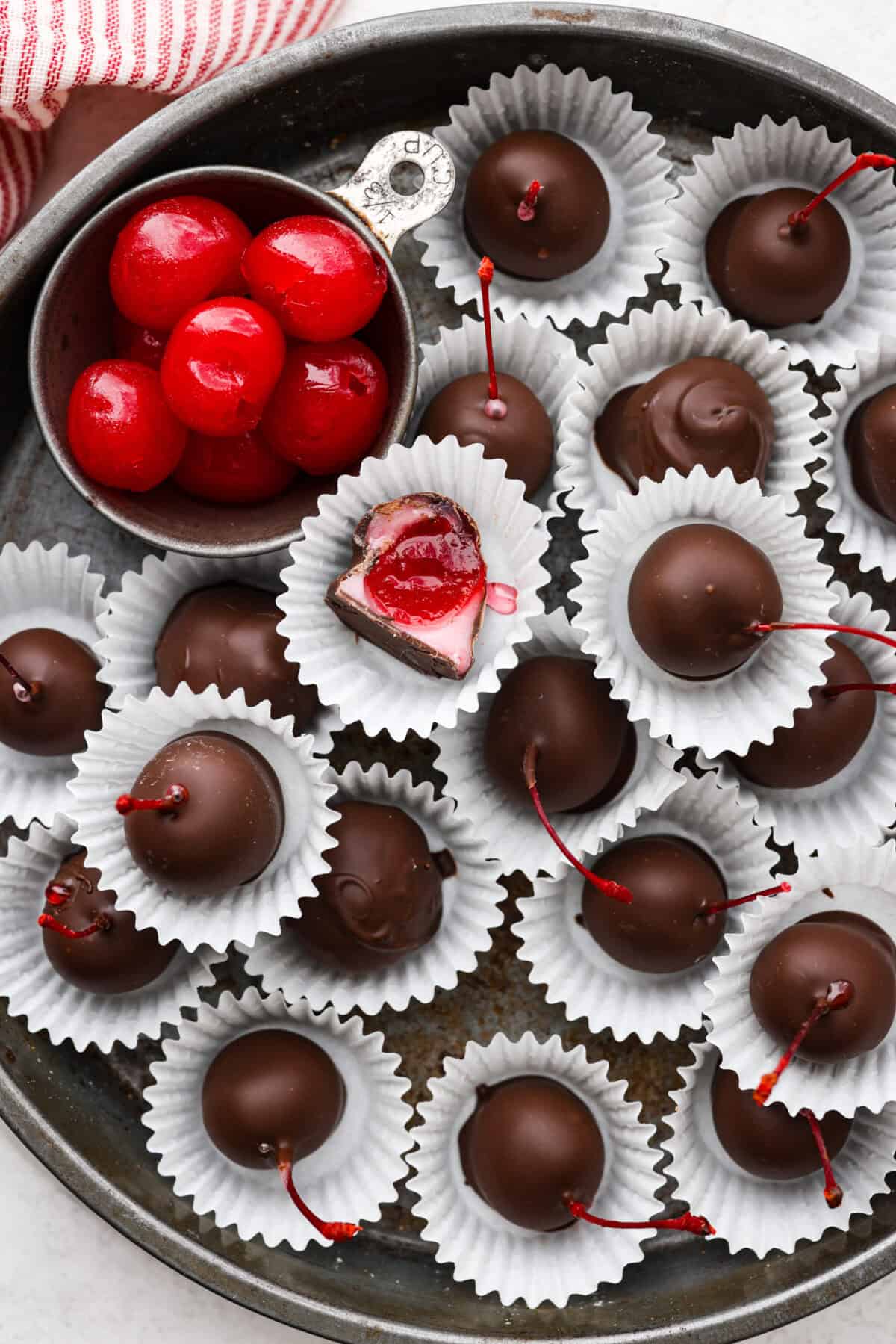 Overhead shot of cherry cordials in paper wrapping on a serving platter. 