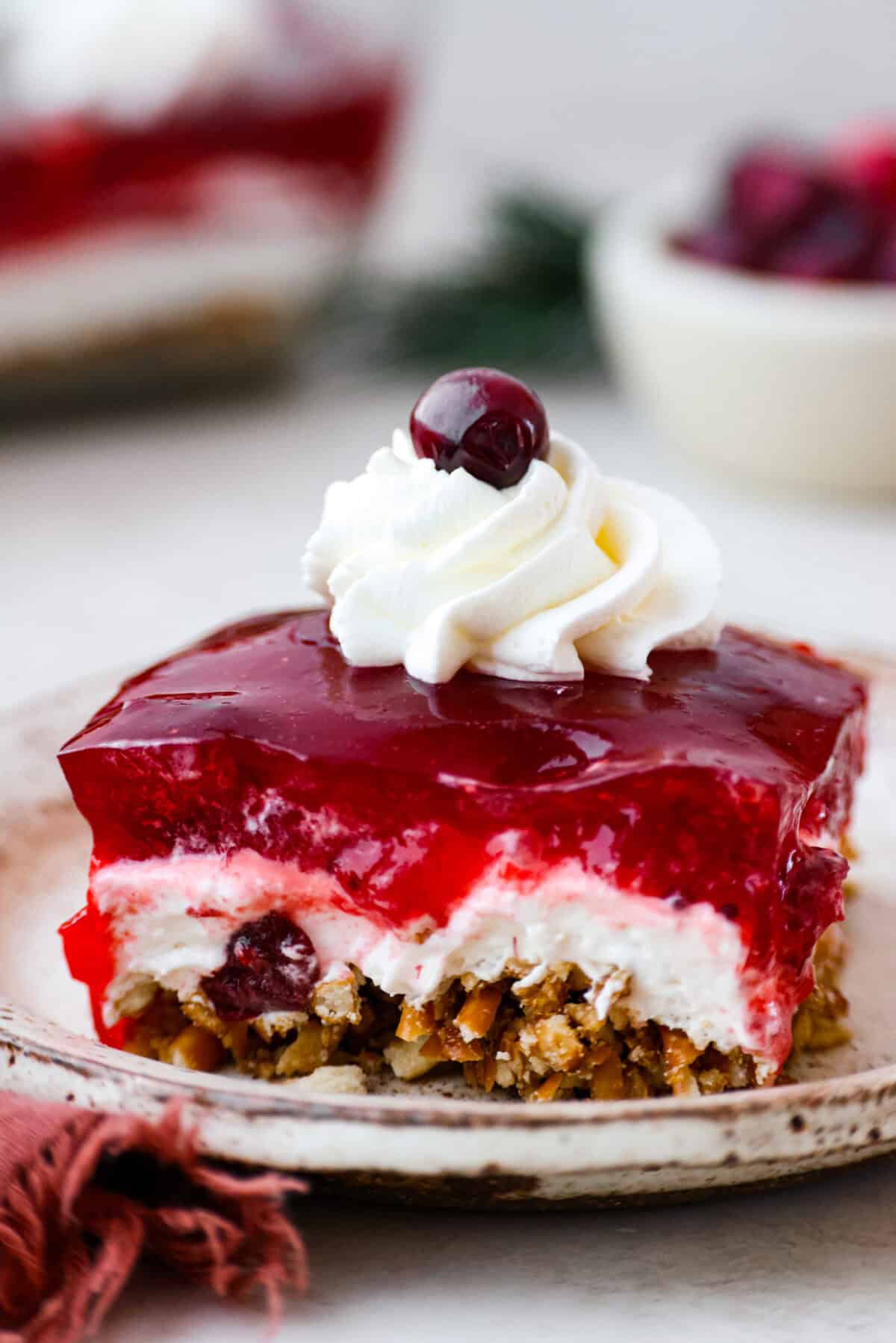 Close view of a slice of cranberry pretzel salad on a plate.