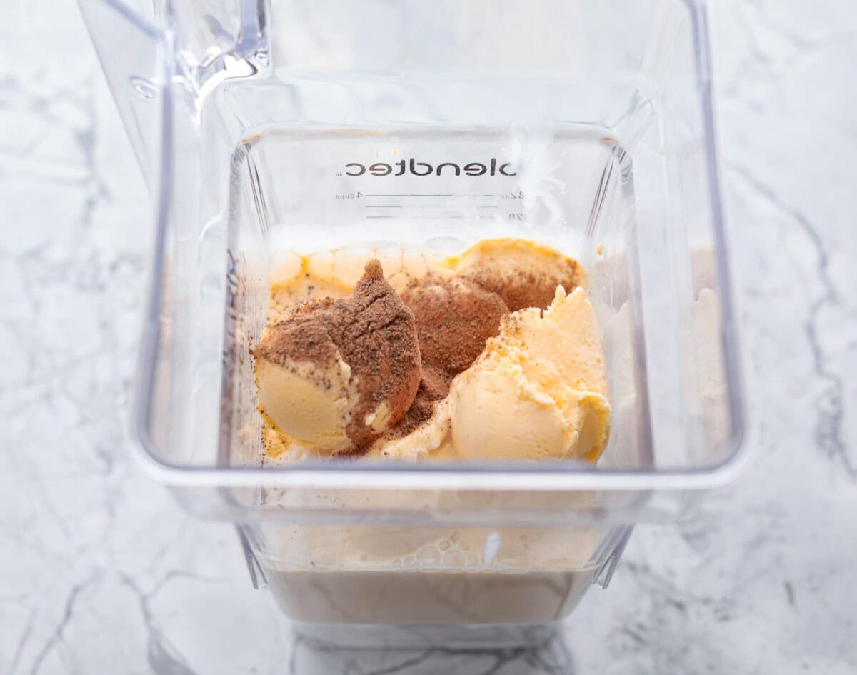 This creamy Eggnog Milkshake is decadent and super flavorful. It takes four simple ingredients and 5 minutes of your time. If you thought you liked eggnog before, you are going to absolutely love it after trying this shake. Overhead shot if ingredients inside of a blender.