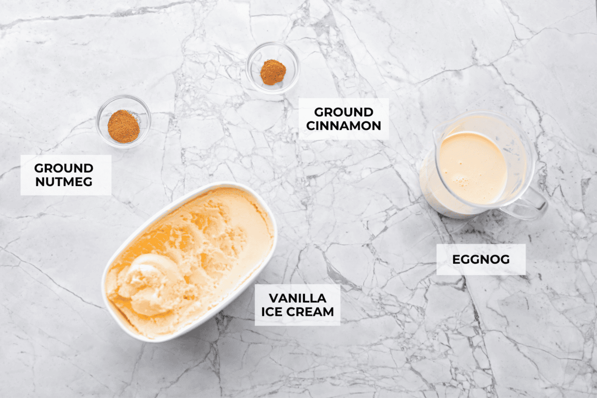 This creamy Eggnog Milkshake is decadent and super flavorful. It takes four simple ingredients and 5 minutes of your time. If you thought you liked eggnog before, you are going to absolutely love it after trying this shake. Overhead shot of labeled ingredients.