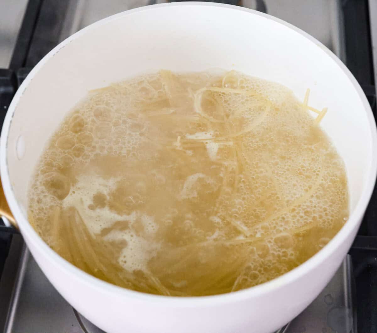 Garlic butter pasta is a quick and simple dish yet packed with flavor. Angel hair pasta is bathed in a buttery garlic sauce and topped with Italian seasoning. Overhead shot of pasta noodles boiling in a pot.