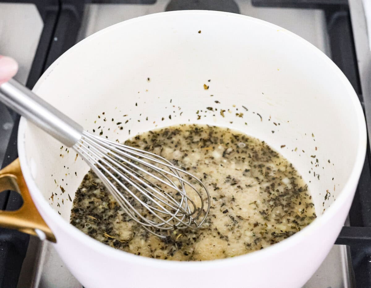 Garlic butter pasta is a quick and simple dish yet packed with flavor. Angel hair pasta is bathed in a buttery garlic sauce and topped with Italian seasoning. Angle shot of the butter and garlic with Italian seasoning mixed in.