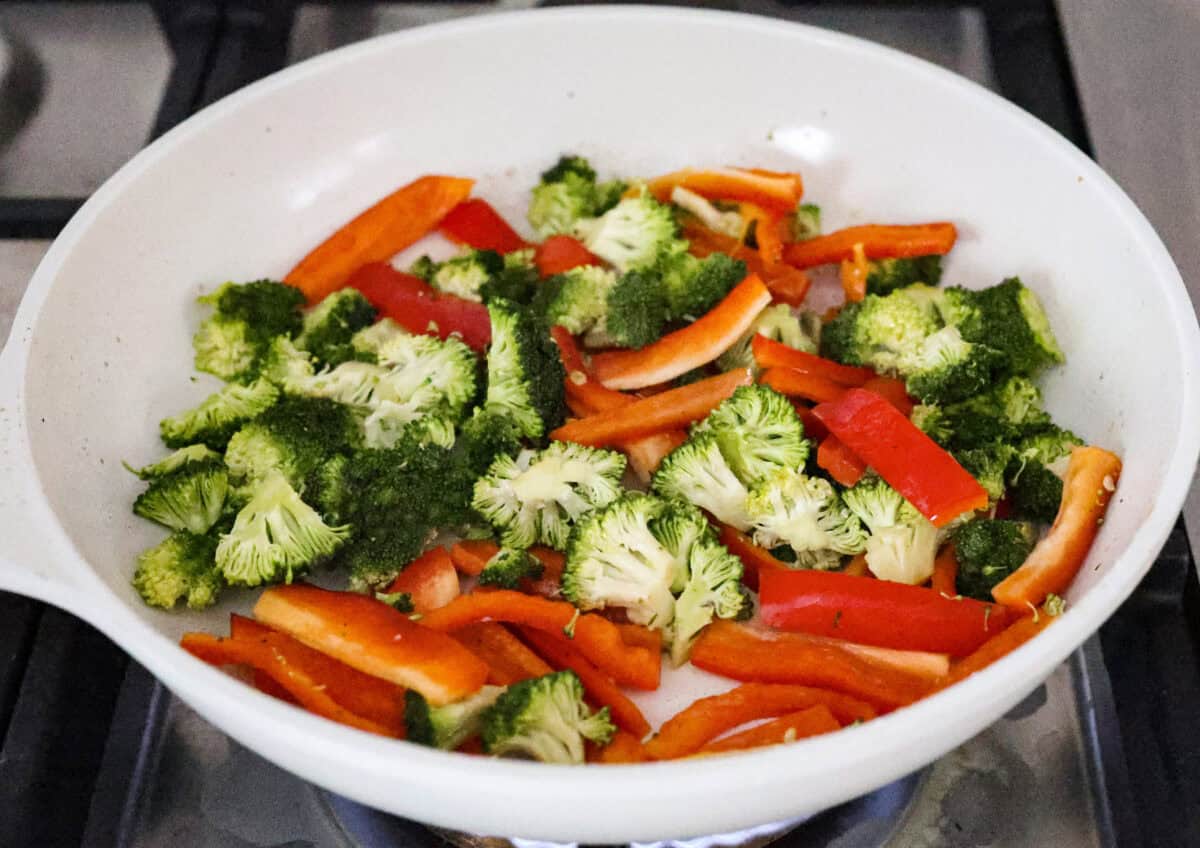 Hunan chicken is a tasty take-out favorite that can be made right at home! Tender chicken and veggies are tossed in the signature hunan sauce. It's savory with a hint of sweet and spicy! This easy one-pan dinner is ready in 30 minutes! Third photo of the veggies cooking in the skillet.
