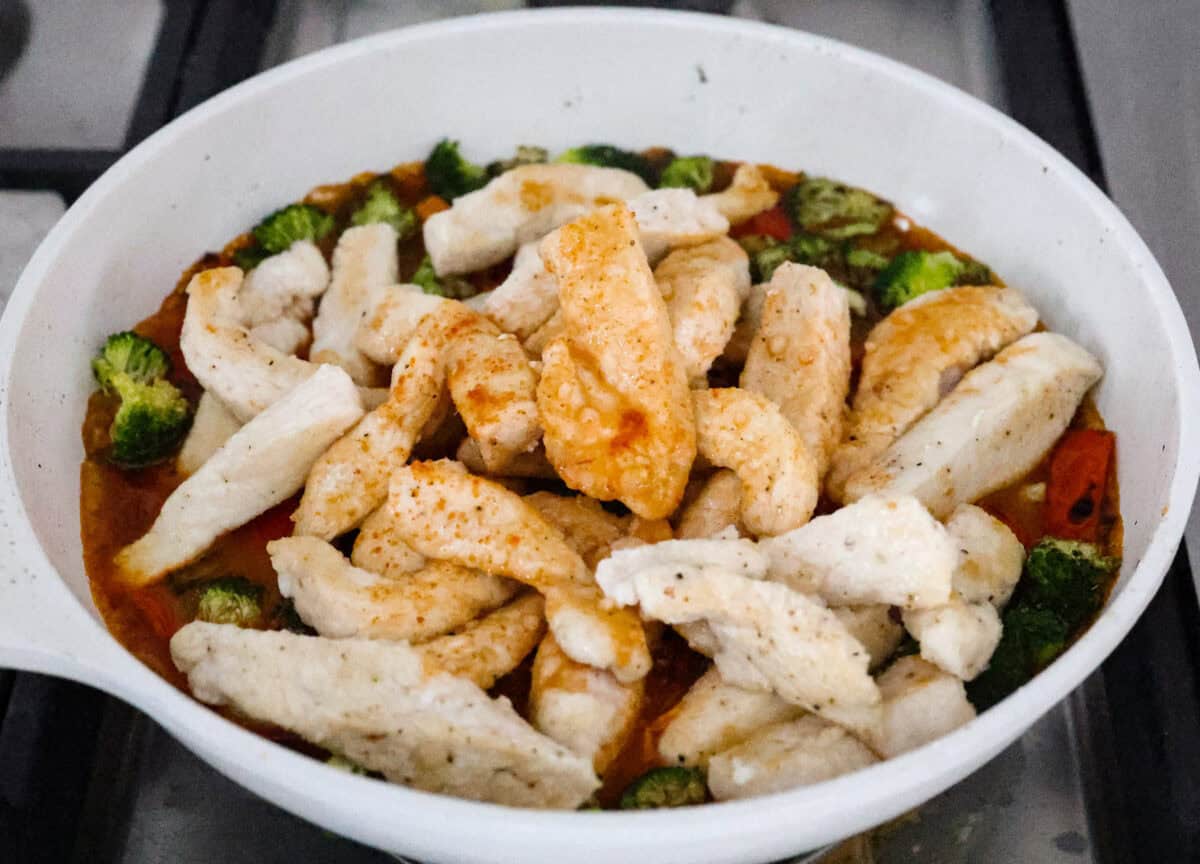 Hunan chicken is a tasty take-out favorite that can be made right at home! Tender chicken and veggies are tossed in the signature hunan sauce. It's savory with a hint of sweet and spicy! This easy one-pan dinner is ready in 30 minutes! Fifth photo of the chicken stir fry and Hunan sauce combined in the skillet.