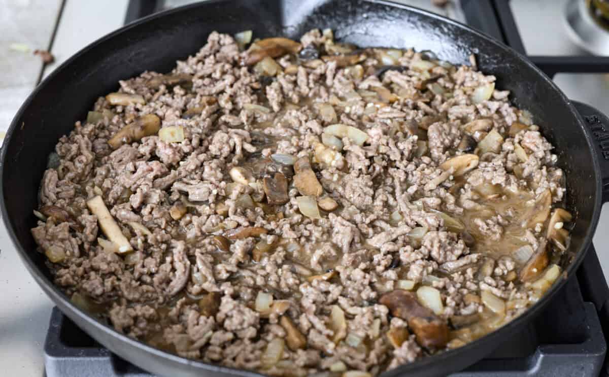 Angle shot of the ground beef mixed into the salisbury steak gravy mixture. 