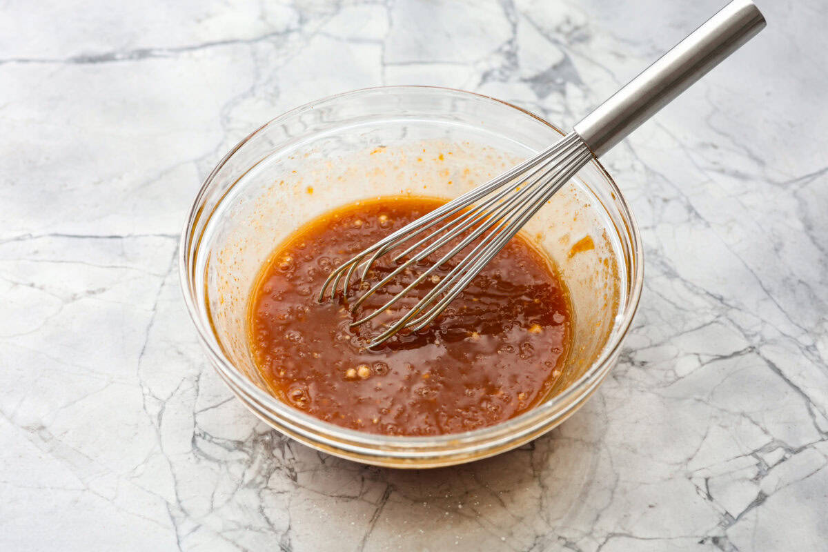 Tender, juicy Slow Cooker Honey Buffalo Meatballs are simmered in the most tantalizing sweet heat sauce that everyone goes crazy for! Perfect appetizer or delicious, easy meal! Overhead shot of sauce ingredients whisked together in a bowl.