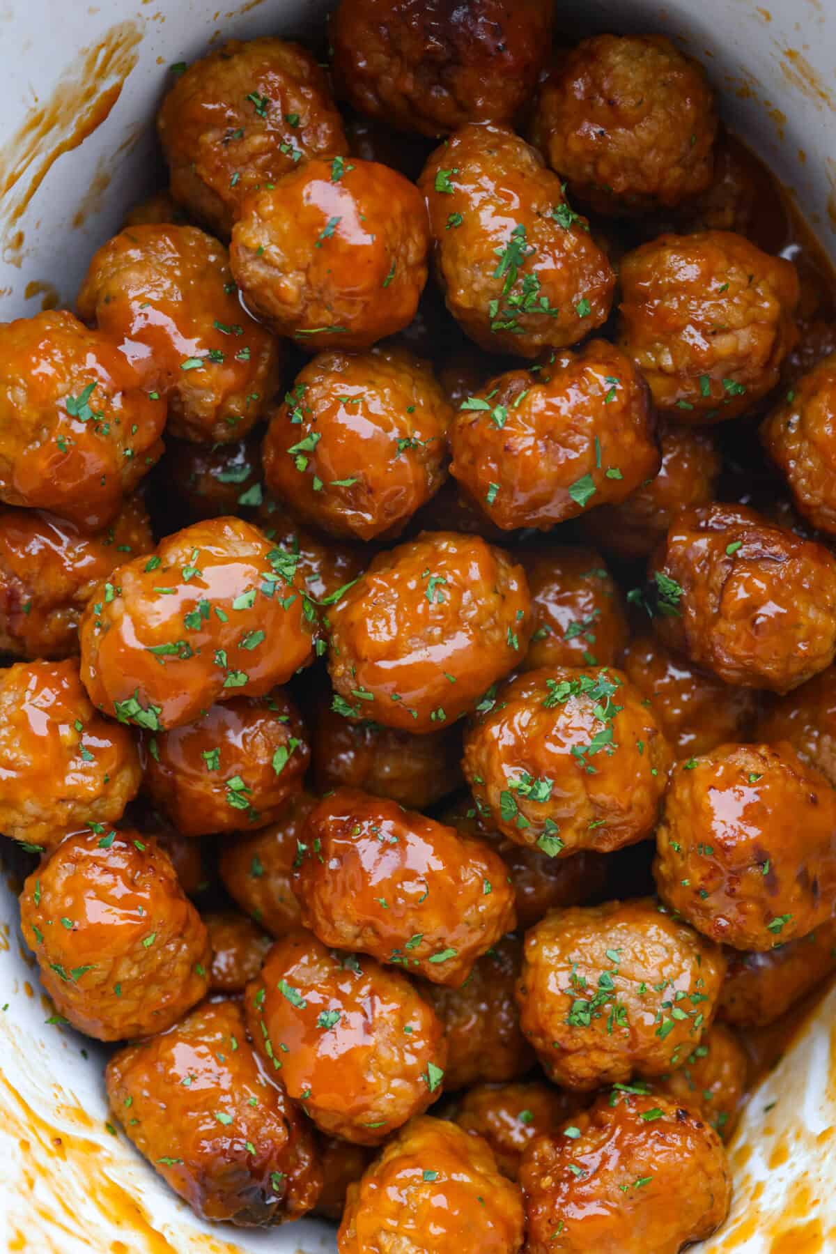 Tender, juicy Slow Cooker Honey Buffalo Meatballs are simmered in the most tantalizing sweet heat sauce that everyone goes crazy for! Perfect appetizer or delicious, easy meal! Overhead shot of slow cooker honey buffalo meatballs.