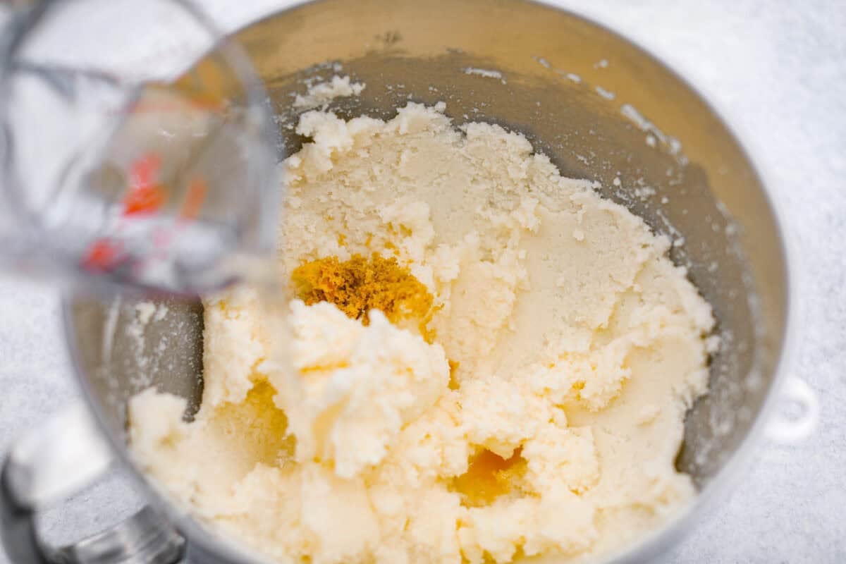 This 7UP Bundt Cake has a buttery texture with a hint of citrusy sweetness. The carbonation in 7UP lifts the batter for a light, fluffy crumb, while the lemon-lime flavor adds a bright, refreshing twist to every bite. Someone pouring 7Up into the creamed butter and sugar with lemon zest, lemon extract and vanilla extract.