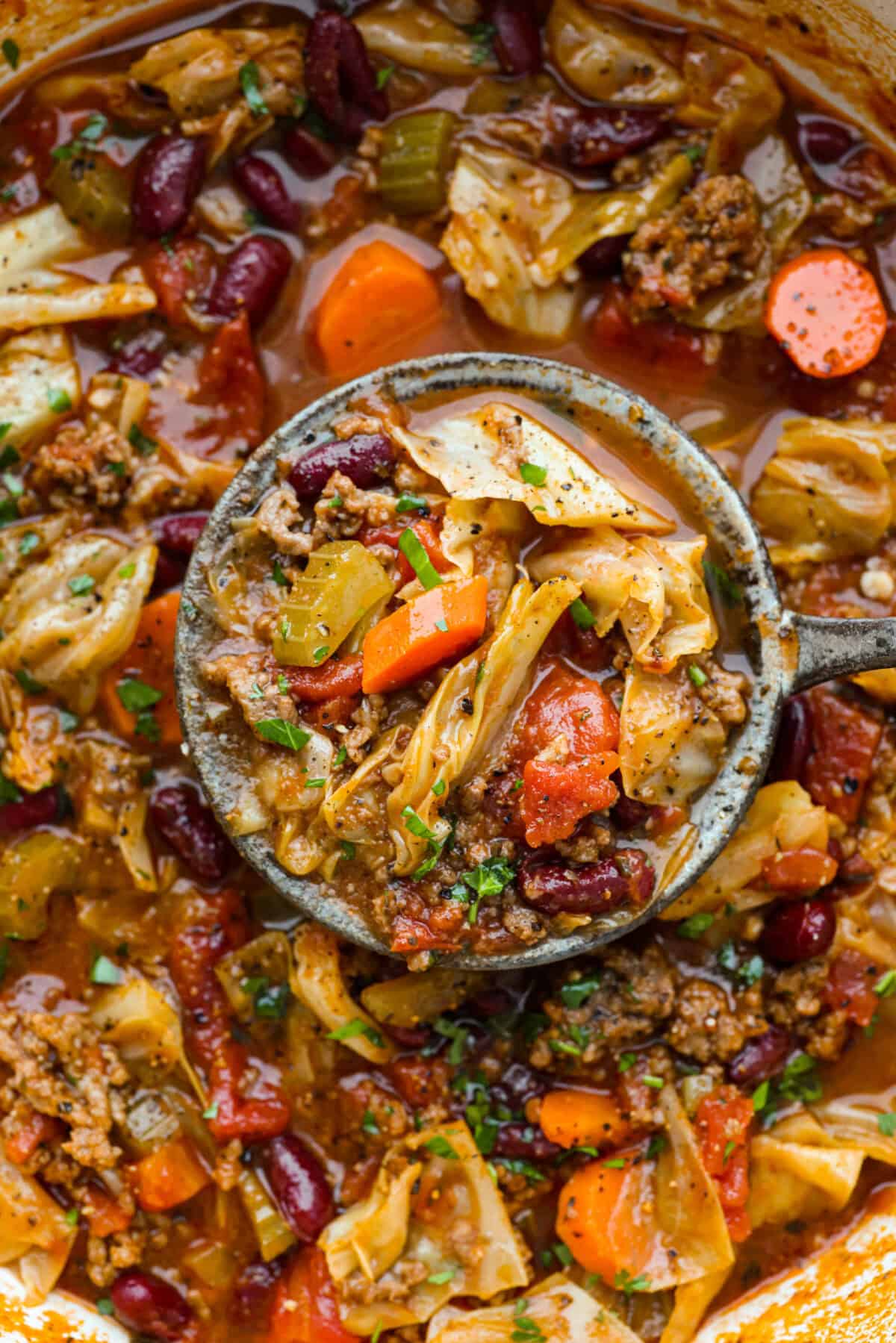 Beef and Cabbage soup is filled with seasoned ground beef, cabbage, carrots, celery, kidney beans, and diced tomatoes. It is hearty, delicious, and full of flavor! This is a great soup to serve on a cold day or to help you get in the spirit of St. Patrick's Day while keeping your nutrition goals in check. Close up shot of beef and cabbage soup.