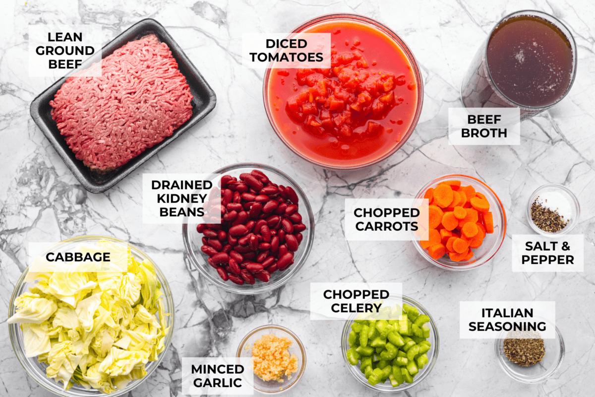 Beef and Cabbage soup is filled with seasoned ground beef, cabbage, carrots, celery, kidney beans, and diced tomatoes. It is hearty, delicious, and full of flavor! This is a great soup to serve on a cold day or to help you get in the spirit of St. Patrick's Day while keeping your nutrition goals in check. Overhead shot of labeled ingredients.
