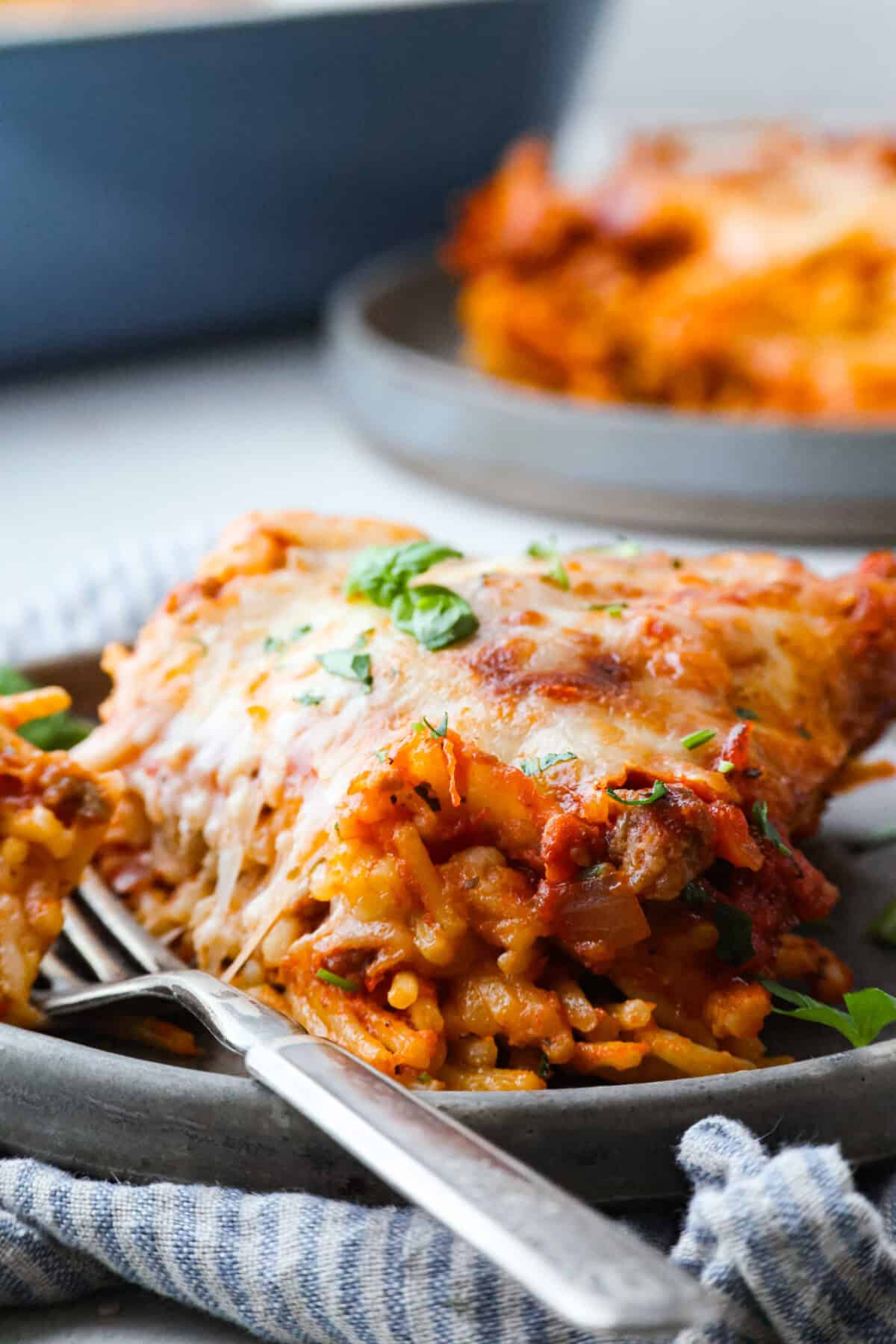 Baked spaghetti is the ultimate comfort food, with noodles that soak up all of the rich sauce as they finish cooking, making every bite extra flavorful. Plus, it’s a lifesaver on busy days. You can prep it ahead, pop it in the oven, and still have a cozy, home-cooked meal without the stress! Close up shot of plated baked spaghetti.