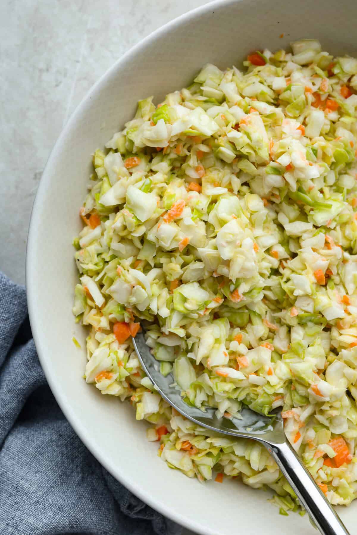 My Copycat KFC Coleslaw is so spot-on, you’ll think it’s the real deal! Crunchy, creamy, tangy, and perfect for any BBQ, everyone will want the recipe! Close up shot of copycat KFC coleslaw in a serving bowl.