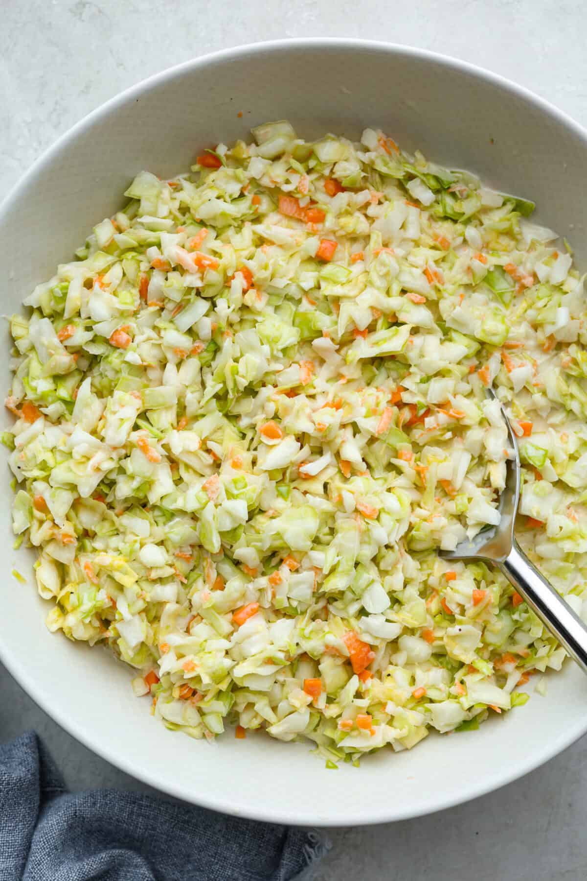 My Copycat KFC Coleslaw is so spot-on, you’ll think it’s the real deal! Crunchy, creamy, tangy, and perfect for any BBQ, everyone will want the recipe! Copycat KFC coleslaw in a serving bowl.
