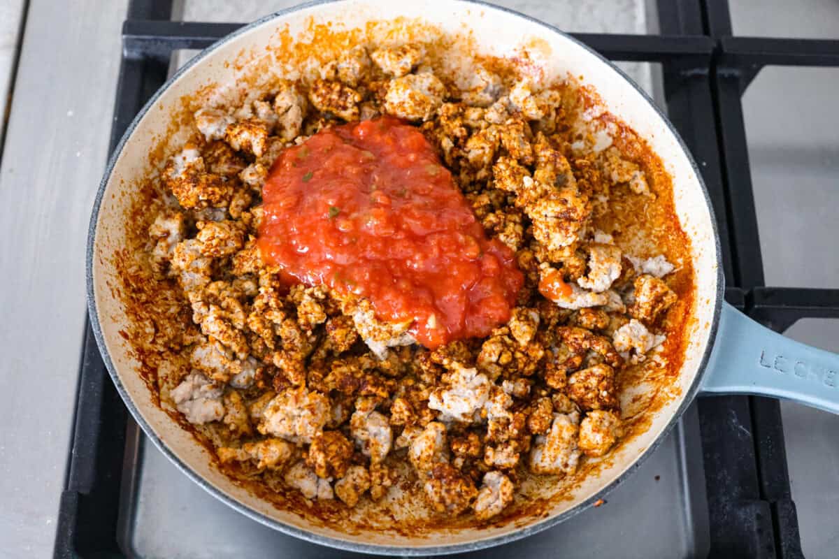 These ground turkey tacos are full of fiesta flavor, all with less fat! Don't let ground turkey steer you away! No one will miss the beef once they taste this taco filling. The seasonings and flavors absorb perfectly into the meat. Overhead shot of turkey and taco seasoning with salsa.