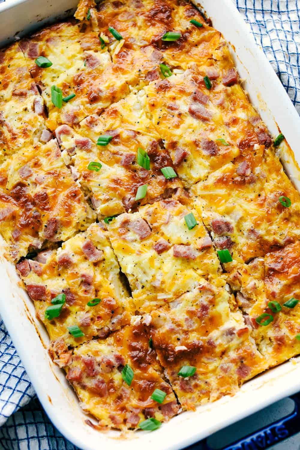 The Best Breakfast Casserole is a thick and creamy egg base with shredded potatoes, chunks of ham and flavorful cheese blends that bakes up in no time. Make ahead or enjoy the morning of during the holidays! breakfast casserole in a dish baked