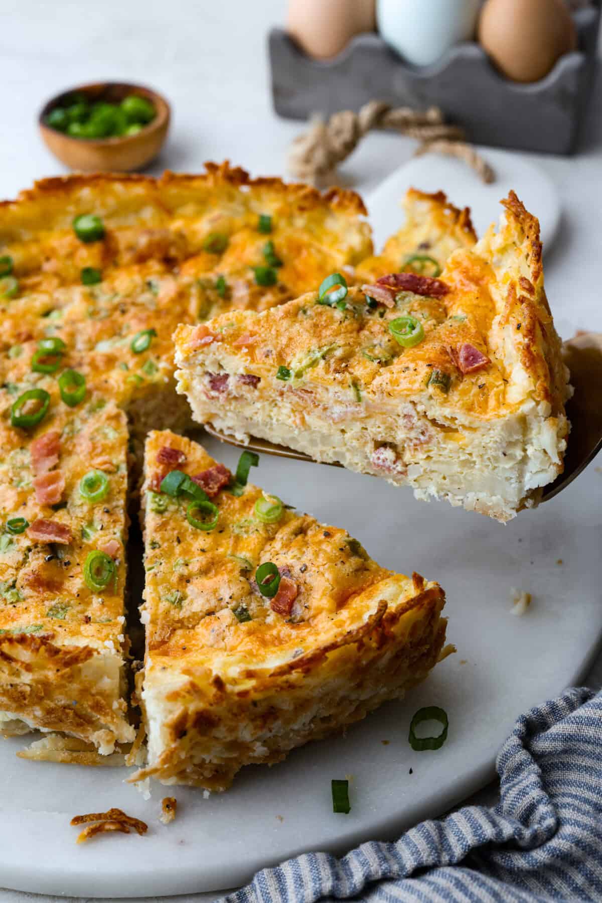 Slice of hash brown crust quiche being lifted out of the pie.