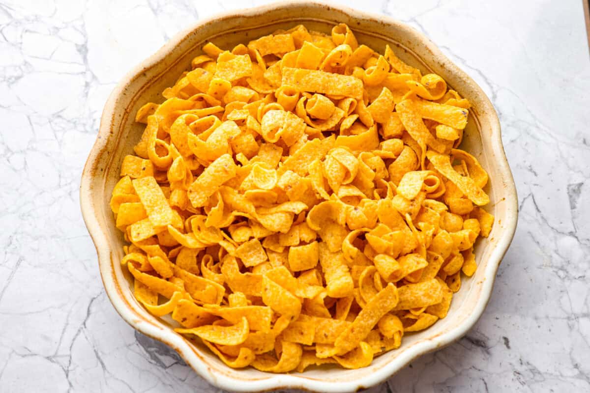 Not to be dramatic, but Frito Chili Pie might have saved my sanity. Zero whining, zero leftovers, it was a total dinner miracle. Crunchy, flavorful and ridiculously easy... you need this in your life ASAP. Frito chips added to the greased pie pan.