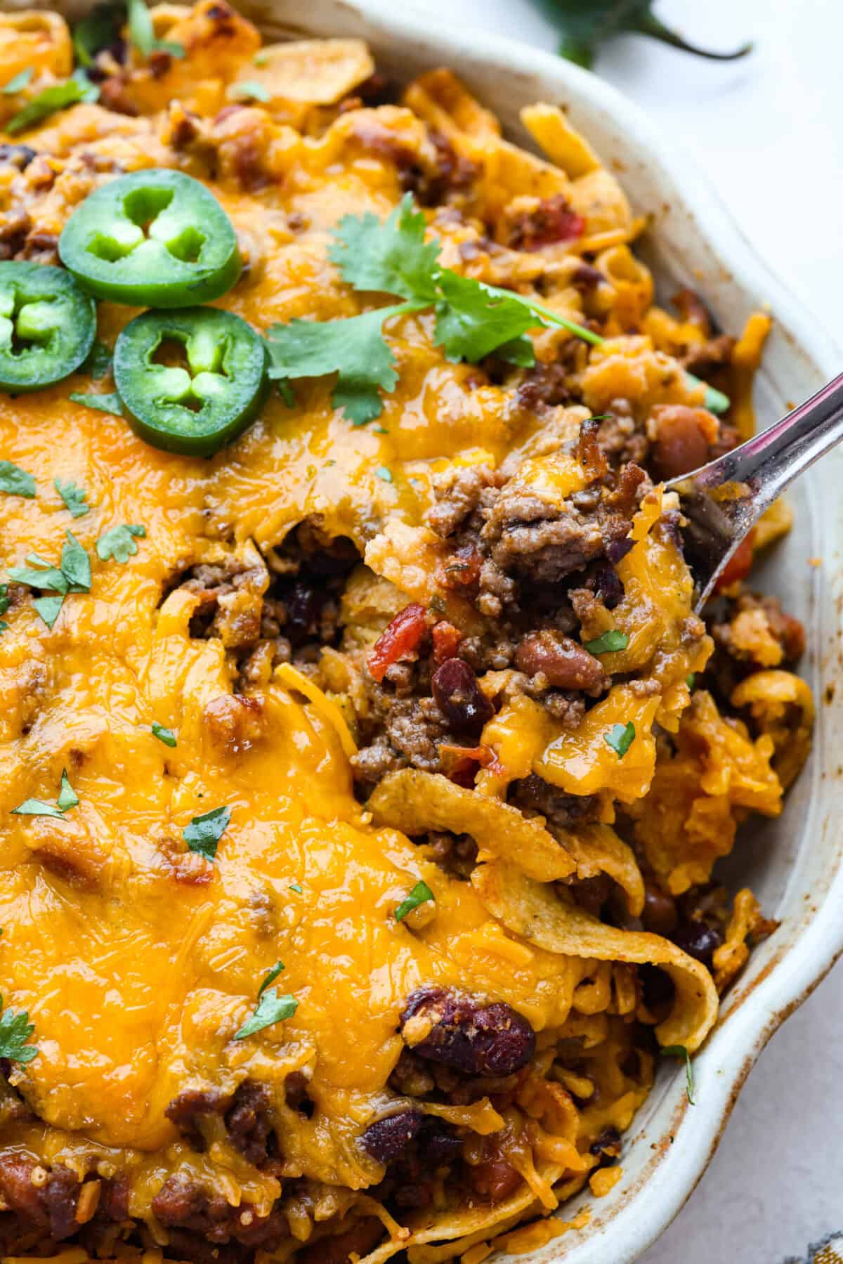 Not to be dramatic, but Frito Chili Pie might have saved my sanity. Zero whining, zero leftovers, it was a total dinner miracle. Crunchy, flavorful and ridiculously easy... you need this in your life ASAP. Close up shot of Frito chili pie.