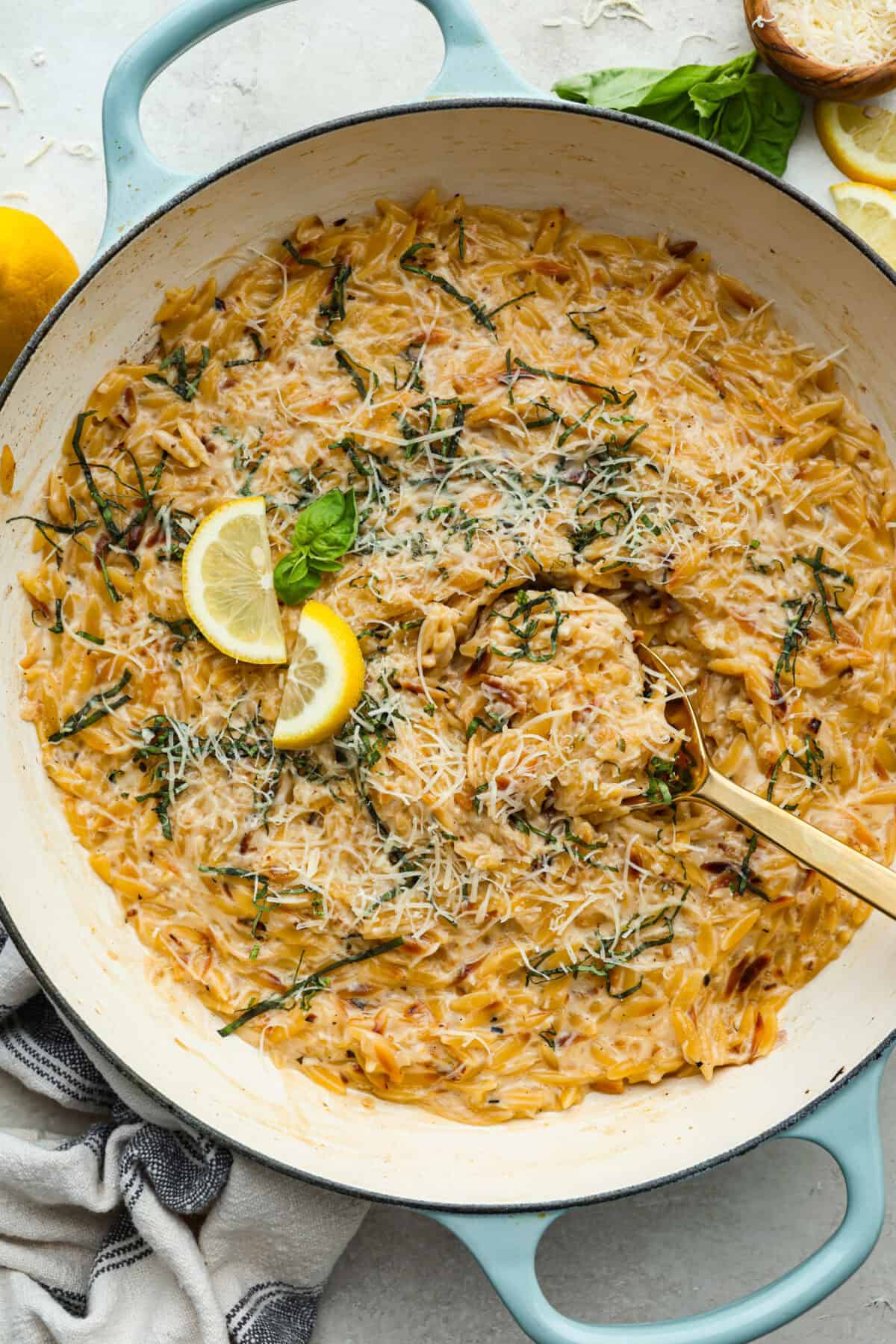 Fresh lemons make me so happy! They’re bright, cheerful, and lift me out of the winter rut. Add that citrusy sunshine to a creamy pasta, and you get this dreamy Creamy Lemon Orzo! Simple, rich, and bursting with feel-good flavor. Cooked creamy lemon orzo in a skillet.