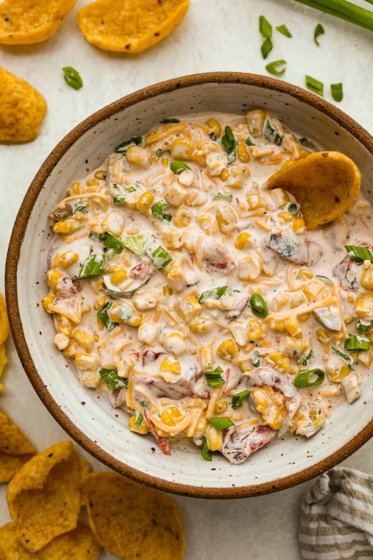 Overhead shot of crack corn dip in a serving bowl with corn chips. 