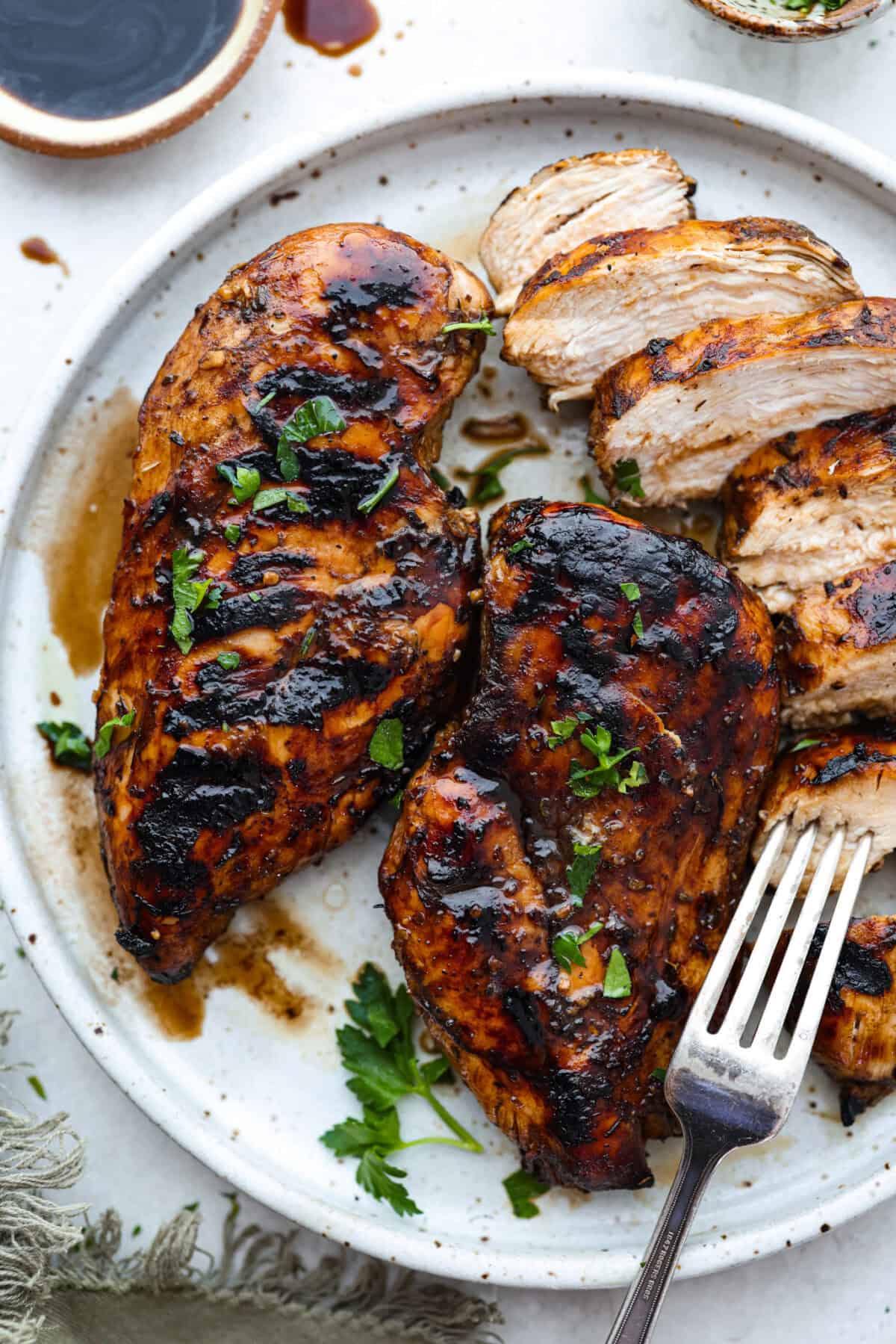 I’ve been on a balsamic kick lately. Drizzling it on salads, veggies, and even watermelon! But this Balsamic Chicken marinade is pure magic. It’s tangy, a little sweet, and somehow makes everyday chicken taste incredible! Overhead shot of grilled chicken that was cooked in balsamic chicken marinade.