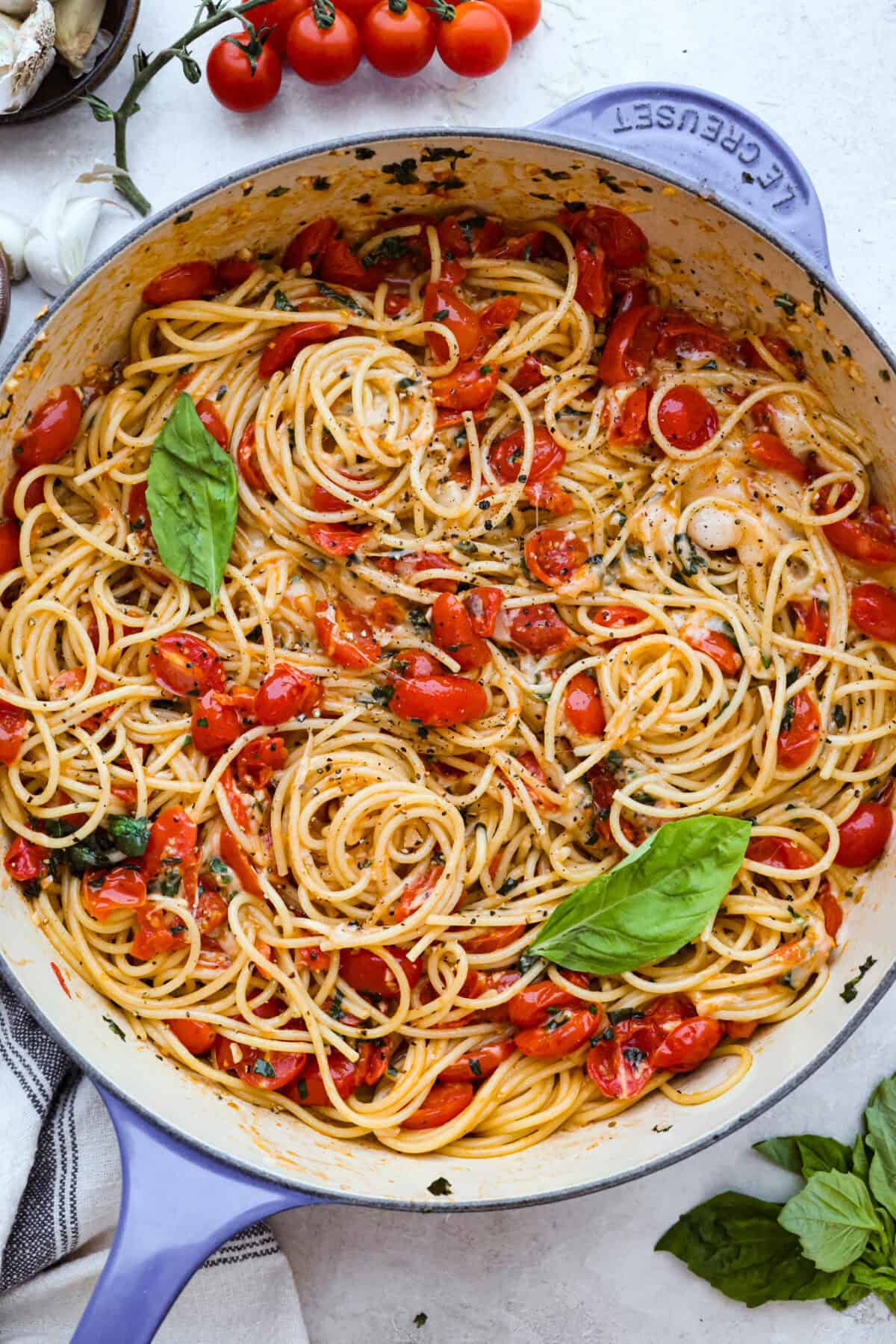 Overhead shot of garnished spaghetti margherita in a skillet. 