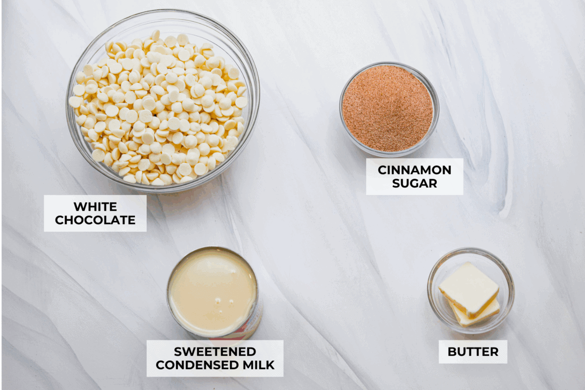 This 4-ingredient churro fudge is pure magic! It's buttery, cinnamon sugary bliss that tastes like a churro and fudge had a baby. It’s easy to make and even easier to gift (if you can resist eating it all first!). Overhead shot of labeled churro fudge ingredients.