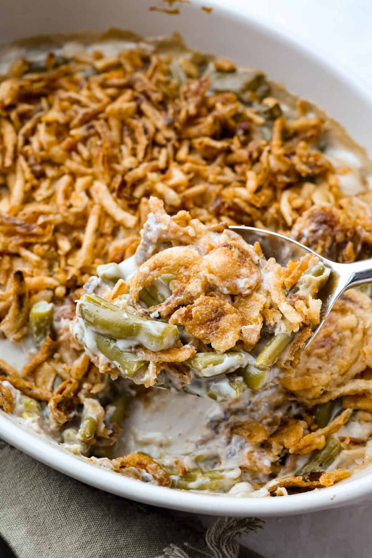 Thanksgiving doesn’t have to mean a long grocery list or an expensive spread. This 5-ingredient green bean casserole keeps things simple, affordable, and classic. It’s proof that comfort food doesn’t need a dozen ingredients. Close up of a scoop of 5 ingredient green bean casserole.