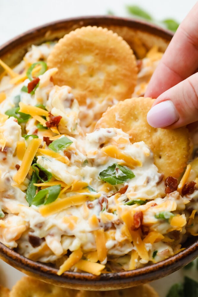 Million Dollar Dip, also known as the famous Neiman Marcus Dip, is creamy, cheesy, and loaded with almonds, green onions, and bacon. It’s the ultimate appetizer that everyone asks for the recipe. Dipping crackers in million dollar dip
