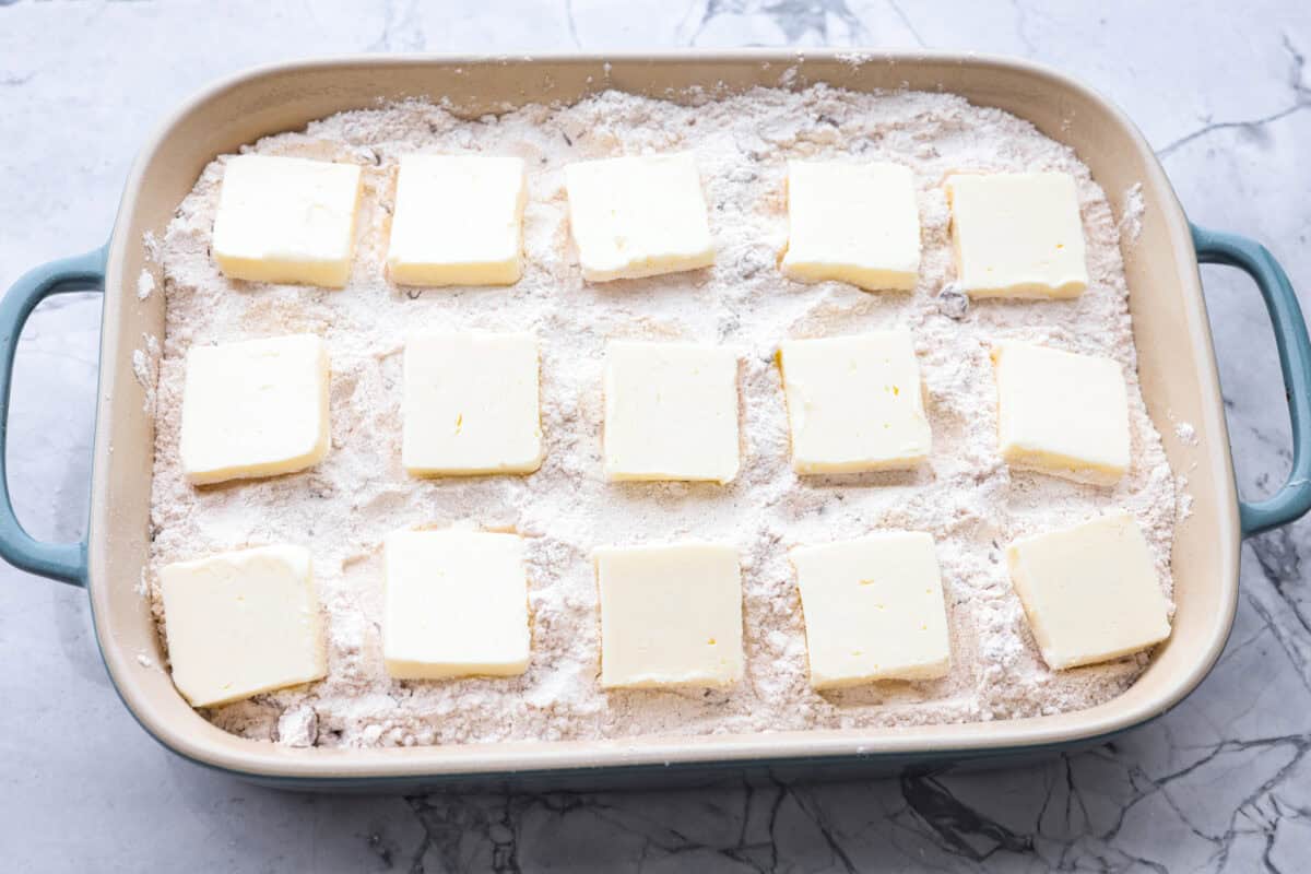 Slices of butter spread out over the top of the cake mix mixture.