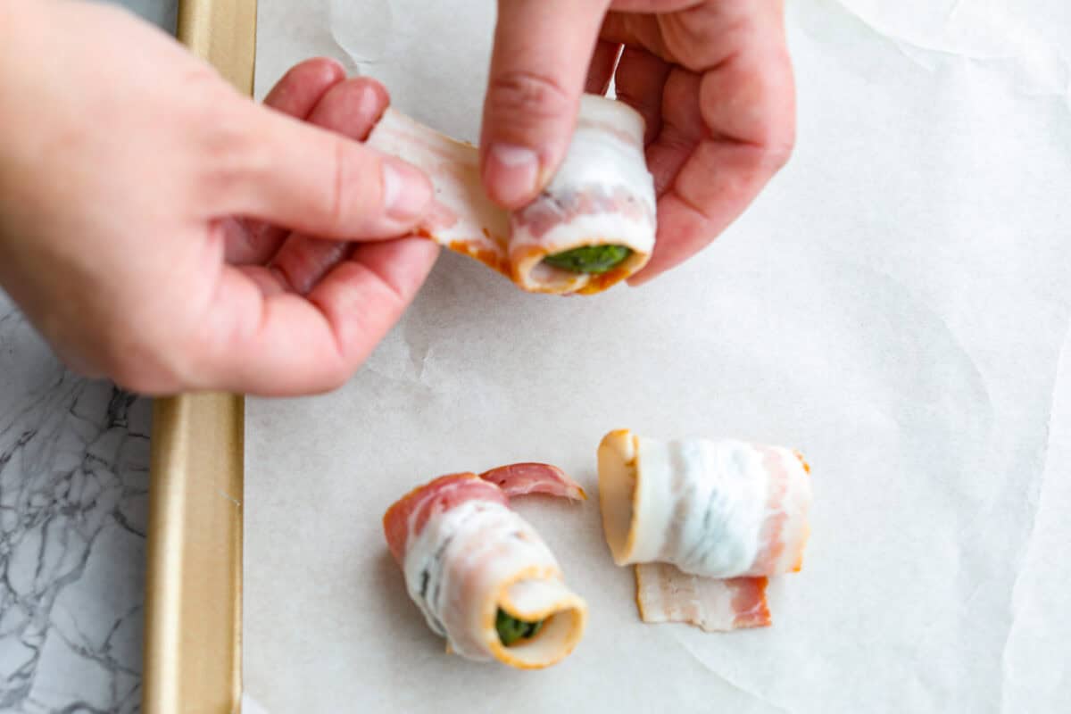 I love bacon. I love Brussels sprouts. Put them together and I’m sold. But the secret to these bacon-wrapped Brussels sprouts? A drizzle of maple syrup! It makes them sweet, smoky, and completely irresistible. Someone wrapping the Brussels sprouts with bacon.