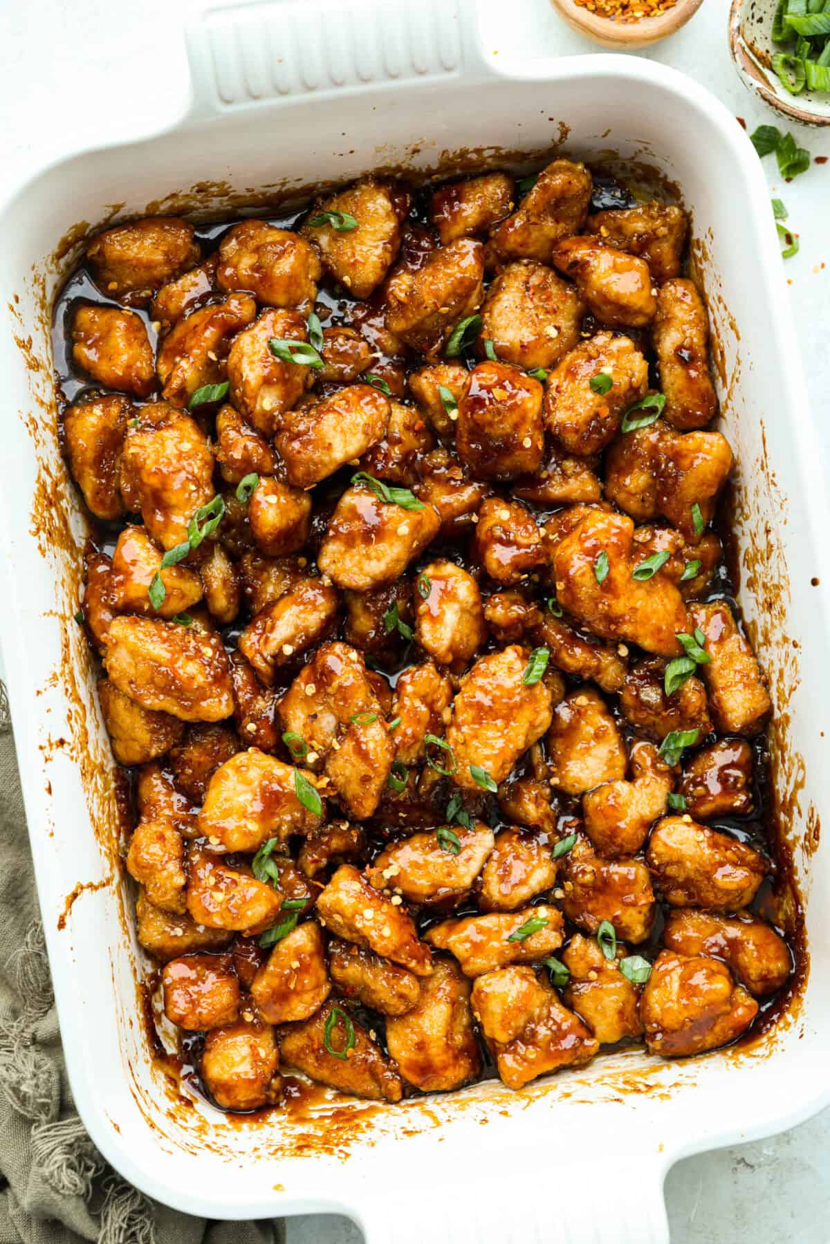 Skip the takeout and make this easy baked General Tso’s chicken at home! It’s crispy, saucy, and perfectly sweet with just the right amount of heat, no deep fryer required. Overhead shot of baked General Tso's chicken in a baking dish.