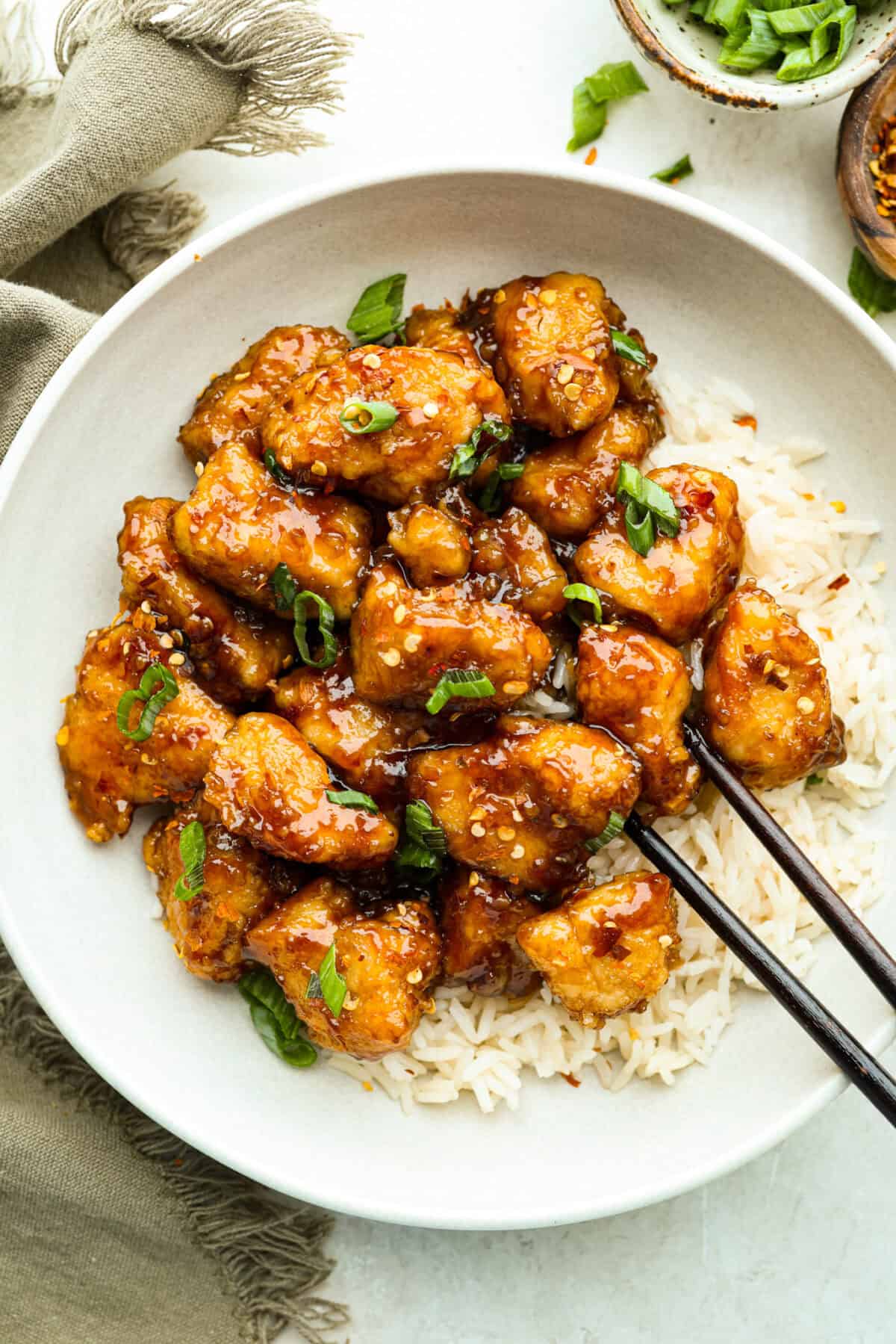 Skip the takeout and make this easy baked General Tso’s chicken at home! It’s crispy, saucy, and perfectly sweet with just the right amount of heat, no deep fryer required. Bowl of General Tso's chicken on a bed of rice.