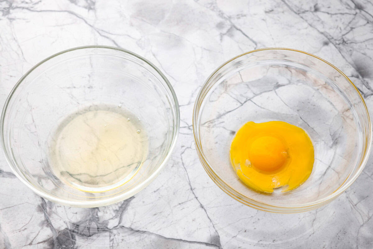 Eggs divided into two bowl. Egg whites in one, and egg yolks in the other. 