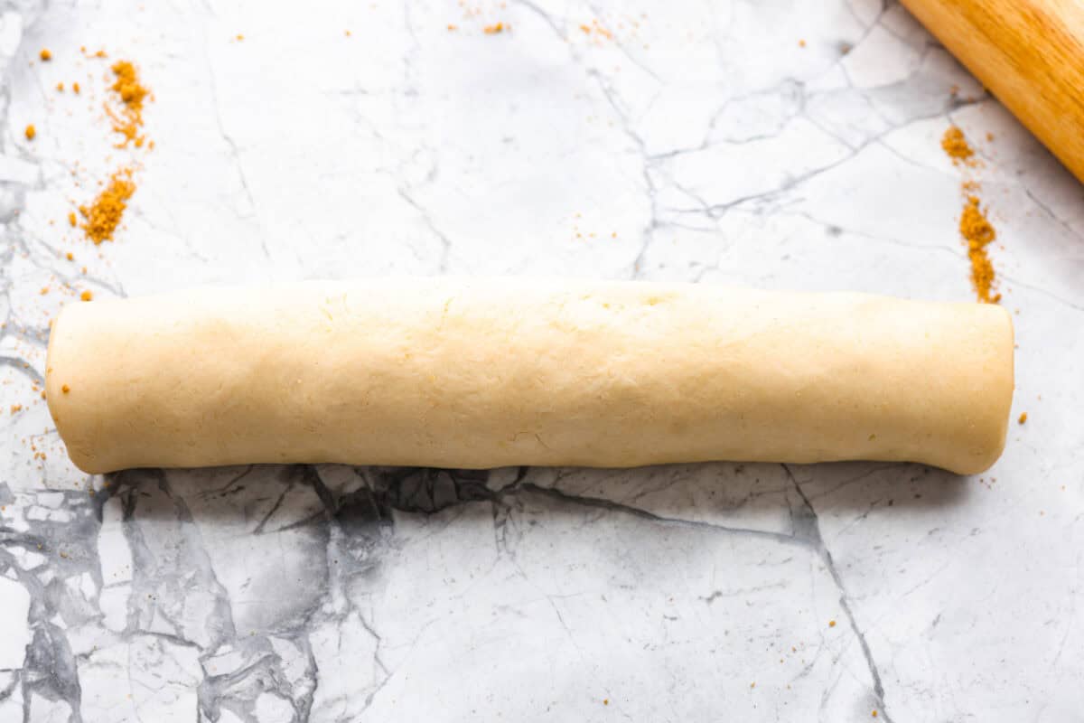 These Caramel Apple Cinnamon Rolls are soft, gooey, and baked with cozy fall flavor in every bite. The homemade dough bakes up perfectly fluffy, and the rich caramel topping makes them feel extra special. Caramel apple cinnamon roll dough and filling rolled up into a log.