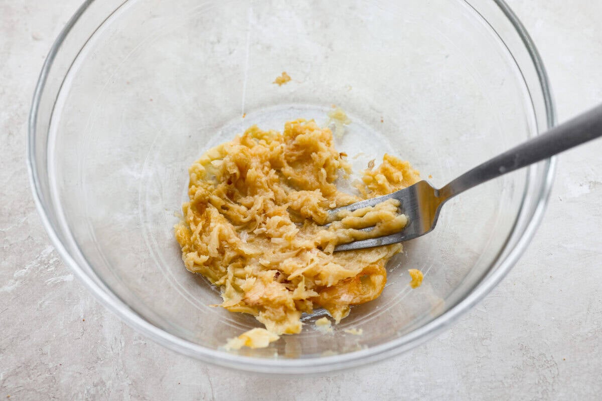 Roasted garlic being smashed into a paste. 