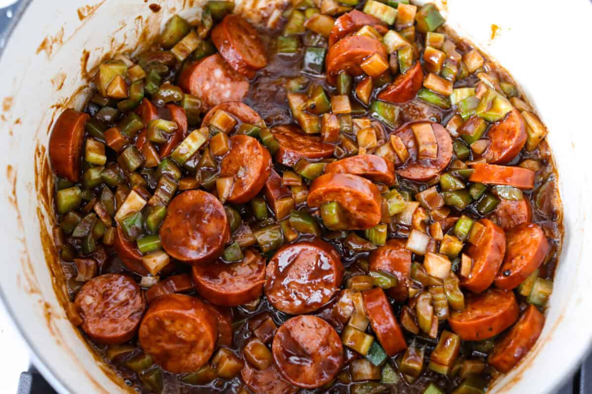 Gumbo is one of those recipes everyone makes differently, but this chicken and sausage gumbo keeps it simple. A dark roux, andouille sausage, and rotisserie chicken give you big flavor with minimal effort. Sausage and veggies added to the pot of roux.