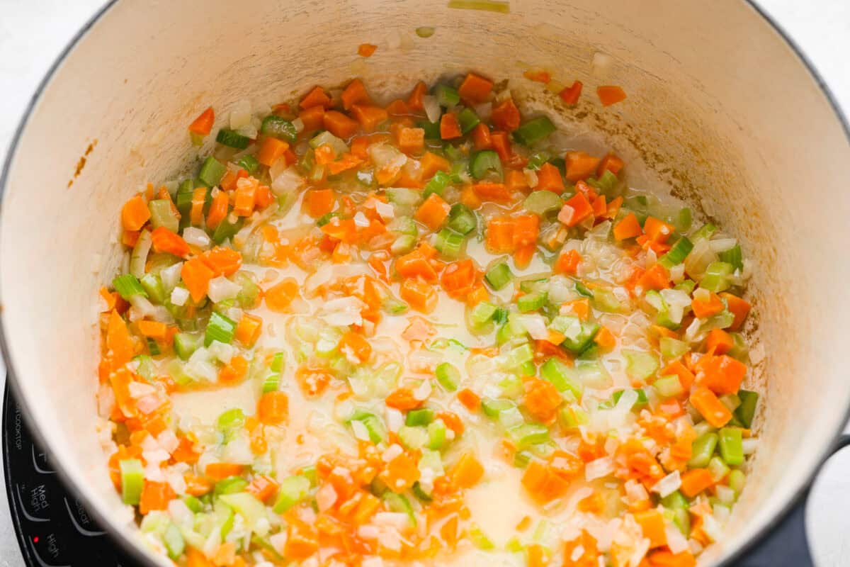 Veggies and butter cooking in a pot.