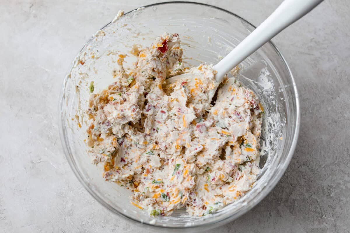 Crack Chicken Egg Rolls wrap savory chicken, crispy bacon, melty cheese, and zesty ranch in a golden, crunchy shell. Easy to make, lighter than deep-fried versions, and perfect for parties or game day! Bowl of crack chicken filling.