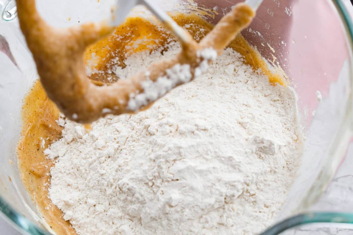 Dry ingredients added to the wet ingredients in the stand mixer bowl.