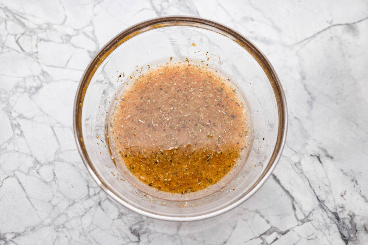 TikTok creator Violet Witchel made this dense bean salad go viral for good reason. It’s simple, high in fiber, protein-packed, and stays delicious for days. My version keeps the same hearty texture and zesty flavor that made her trend explode. Overhead shot of all of the dressing ingredients added to a bowl and whisked together.