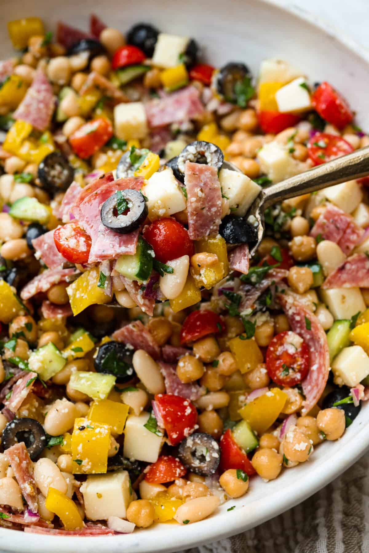 TikTok creator Violet Witchel made this dense bean salad go viral for good reason. It’s simple, high in fiber, protein-packed, and stays delicious for days. My version keeps the same hearty texture and zesty flavor that made her trend explode. Close up of a spoonful of dense bean salad.