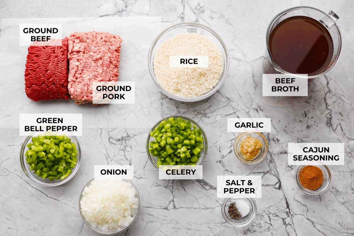 Why is it called “dirty” rice? The rice gets brown as it cooks with meat, Cajun spices, and the holy trinity of Cajun cooking: onion, bell pepper, and celery. My version combines ground pork and beef for a flavorful twist on this Louisiana classic! Overhead shot of labeled dirty rice ingredients.