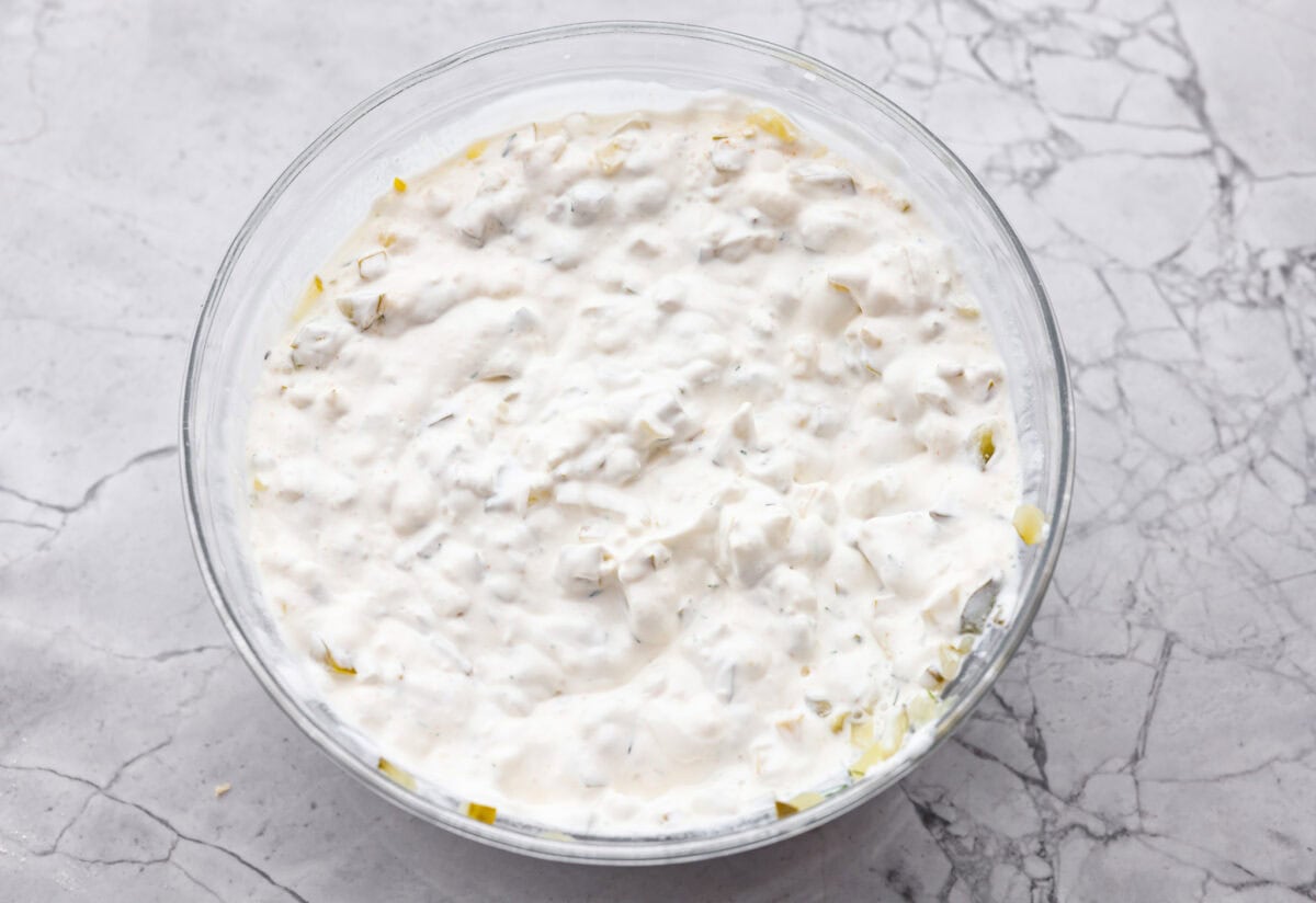 Meet my Fried Pickle Dip...a viral take on my popular pickle dip! The toasted bread crumbs elevate the flavors with the crunchy "fried" texture. Dip ingredients mixed together in a bowl.