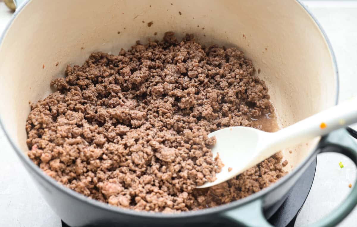 Ground beef cooking in a dutch oven.