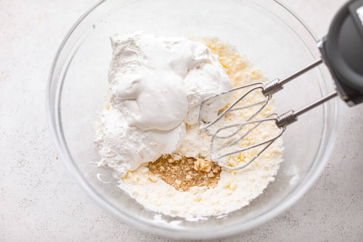 Marshmallow cream topping ingredients added to a bowl.