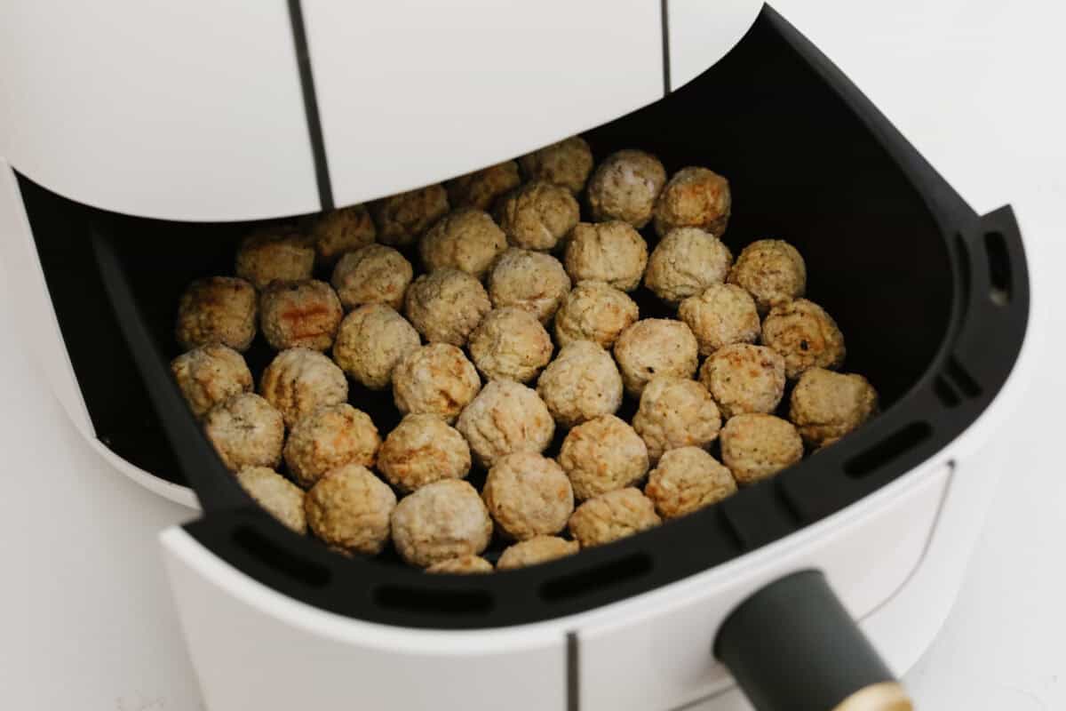 Okay, hear me out, frozen meatballs in the air fryer are a total game-changer. They come out crispy on the outside, juicy on the inside, and taste like you made them from scratch (but without the effort). I use them ALL the time! Meatballs spaced out in the air fryer.